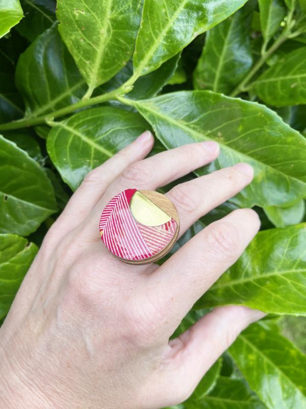 Trendy Fashion Ring, handmade from birch ply wood and hand screened paper in shades of red, while and gold. Come with gold hammered base