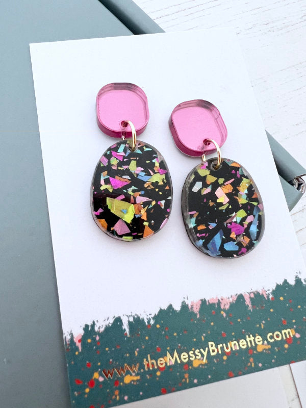 Colorful earrings on a card with 'the messy Brunette' branding.