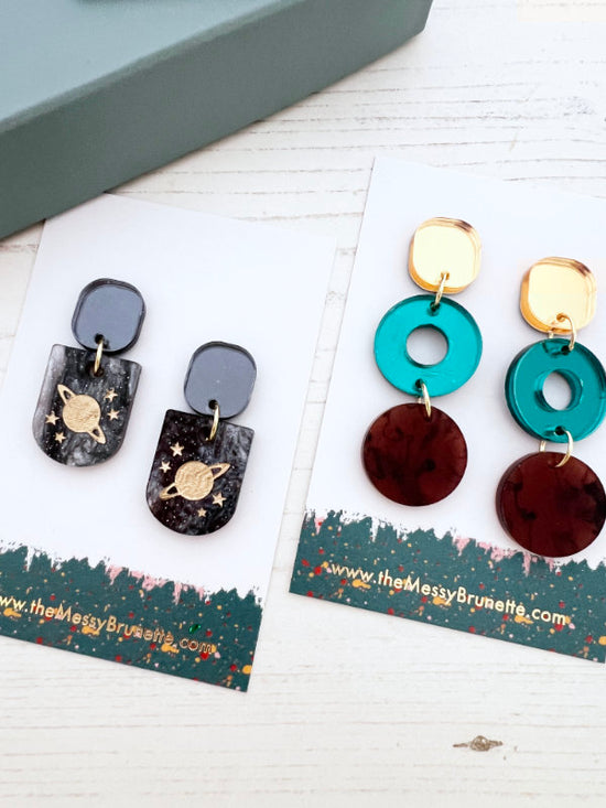Pair of earrings on display with branded card