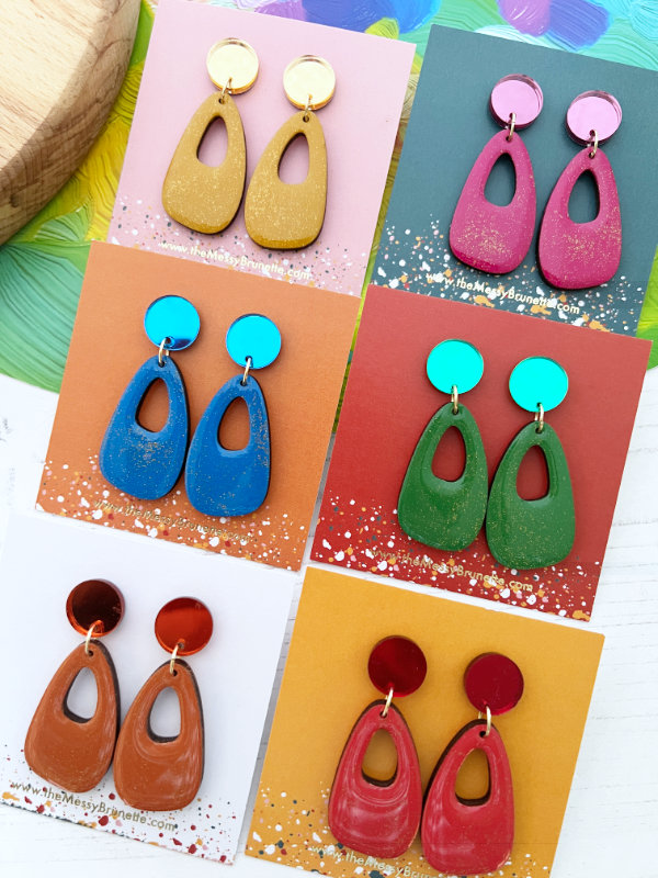 Colorful earrings on display with a multicolored background by The Messy Brunette Jewellery Brand