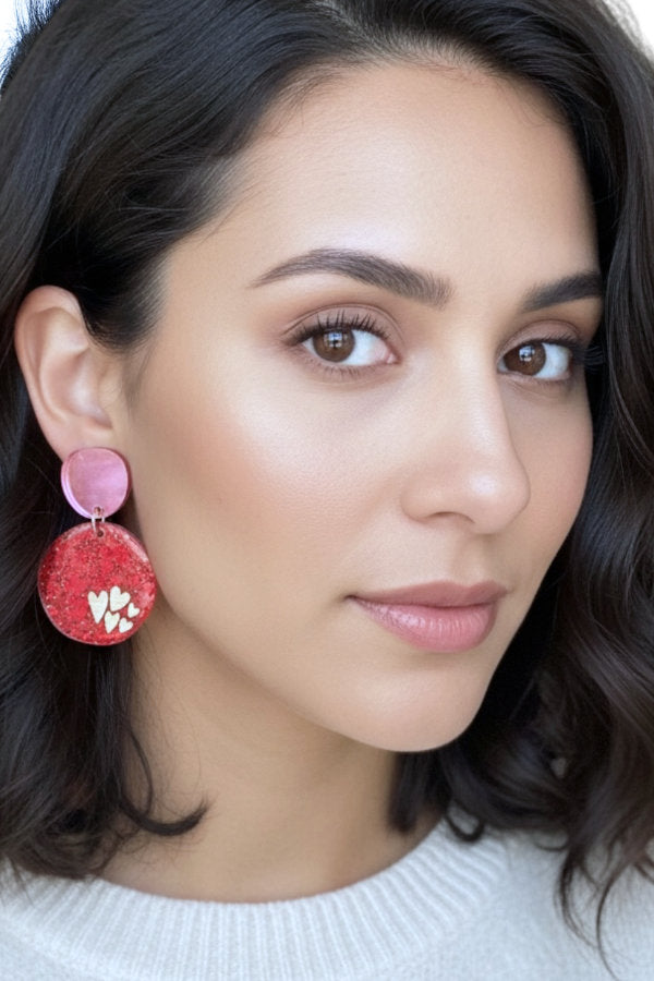 Close-up of a woman wearing pink earrings with a neutral background