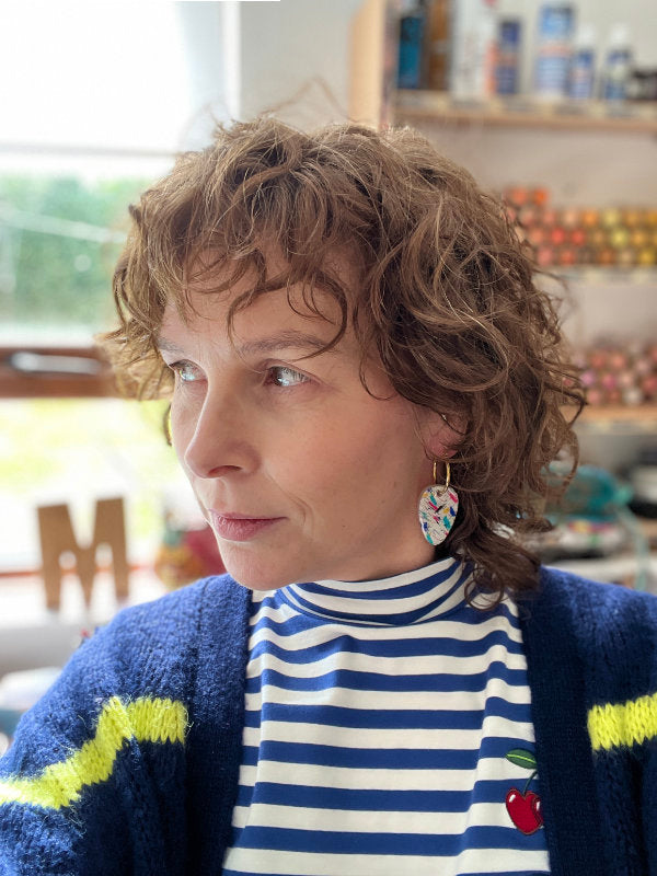 woman wearing paint splashes drop earrings on hoops