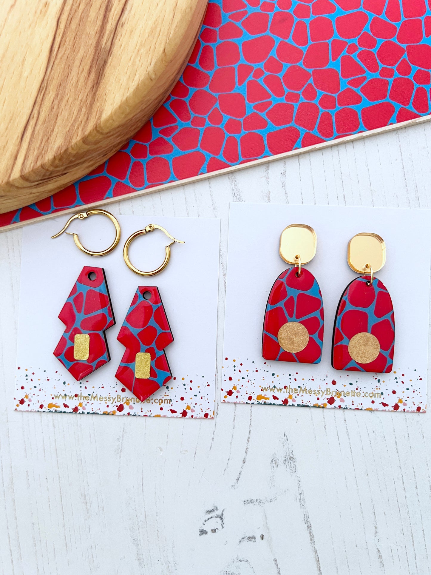 red and blue safari print wooden earrings in 2 styles surrouded on a white background