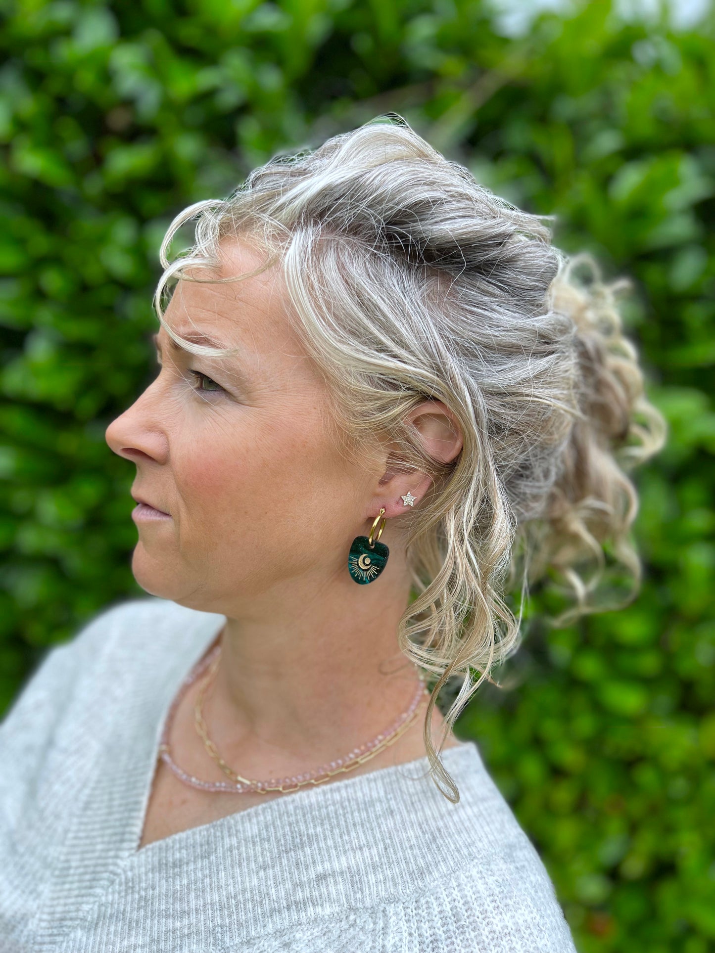 Woman with styled hair wearing celestical hoops earrings