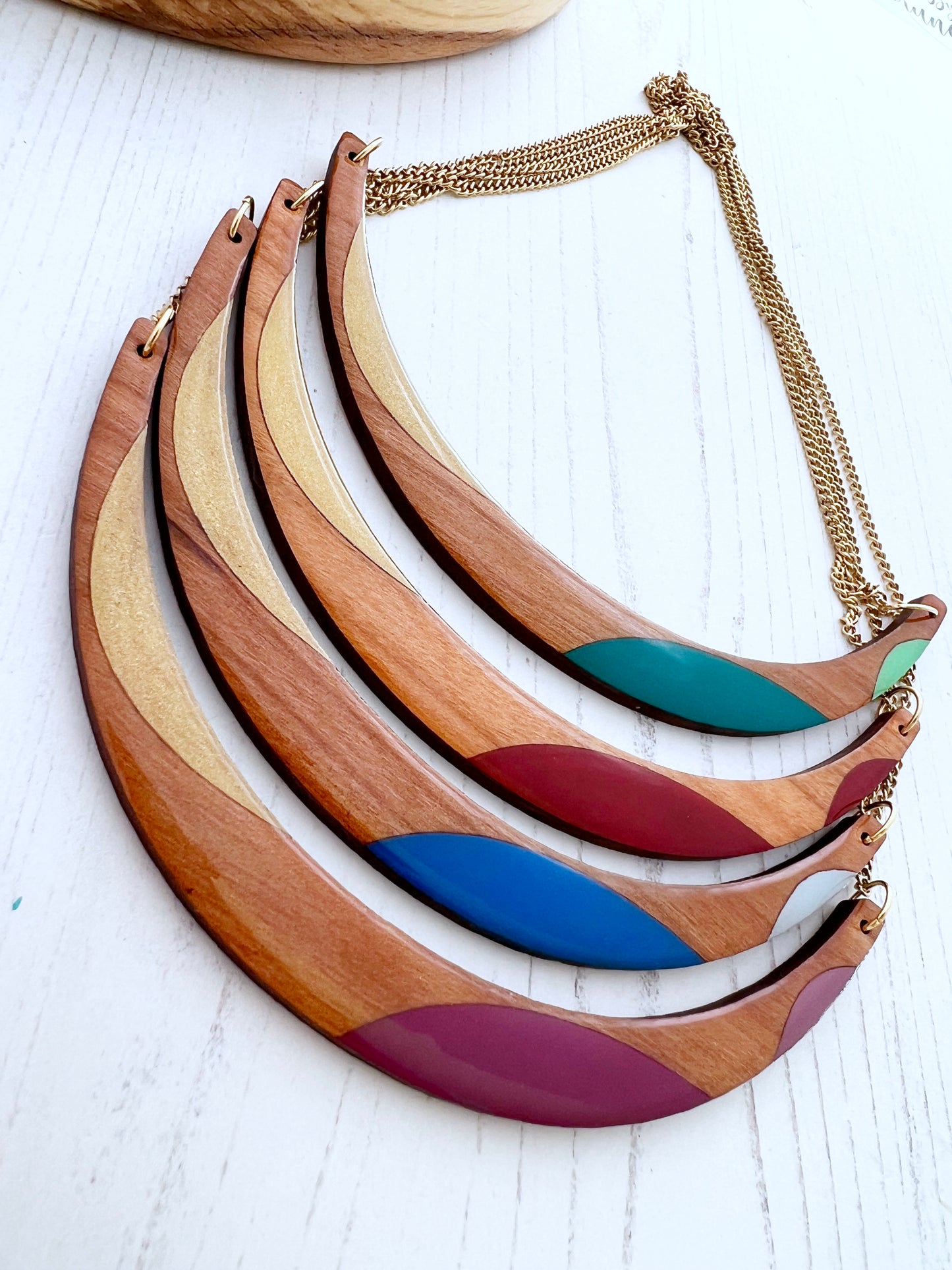 Hand paintd wooden necklace with colourful accents on a white surface