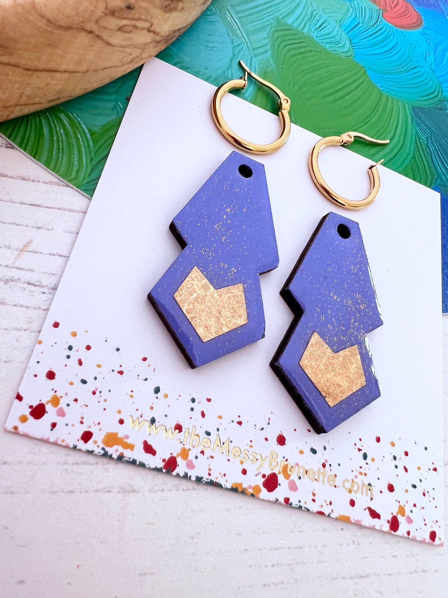 Geometric periwinkle blue and gold earrings on a colourful card with 'The Messy Brunette' jewellery branding card