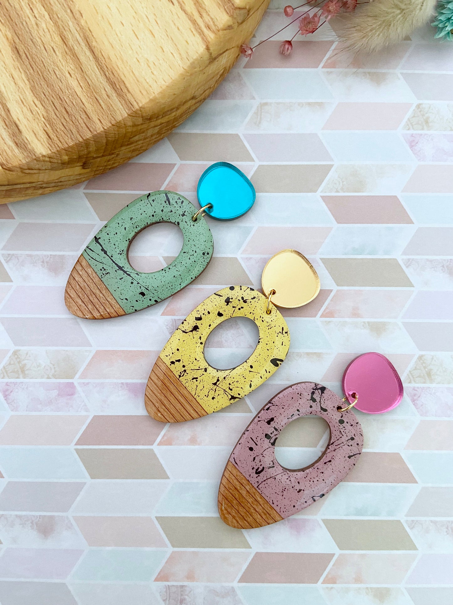 Set of colourful oval colour block splatter earrings on a patterned surface