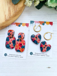 Colorful mini blossom floral patterned earrings a branded card one pair has studs and the other is paired with hoops.