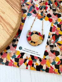 Necklace with a colourful mosaic tile effect on a patterned card with The Messy Brunette branding