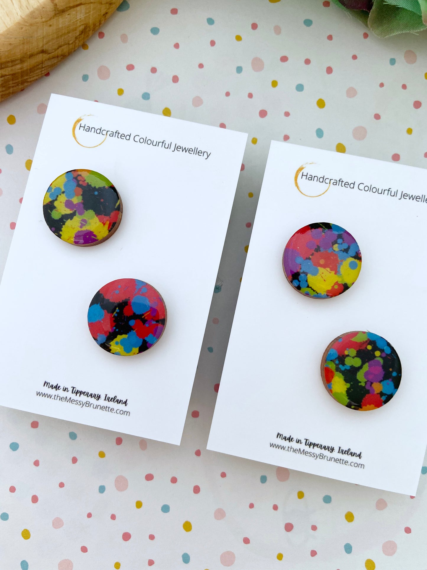 Multi colour round wood earrings on a spotty background 