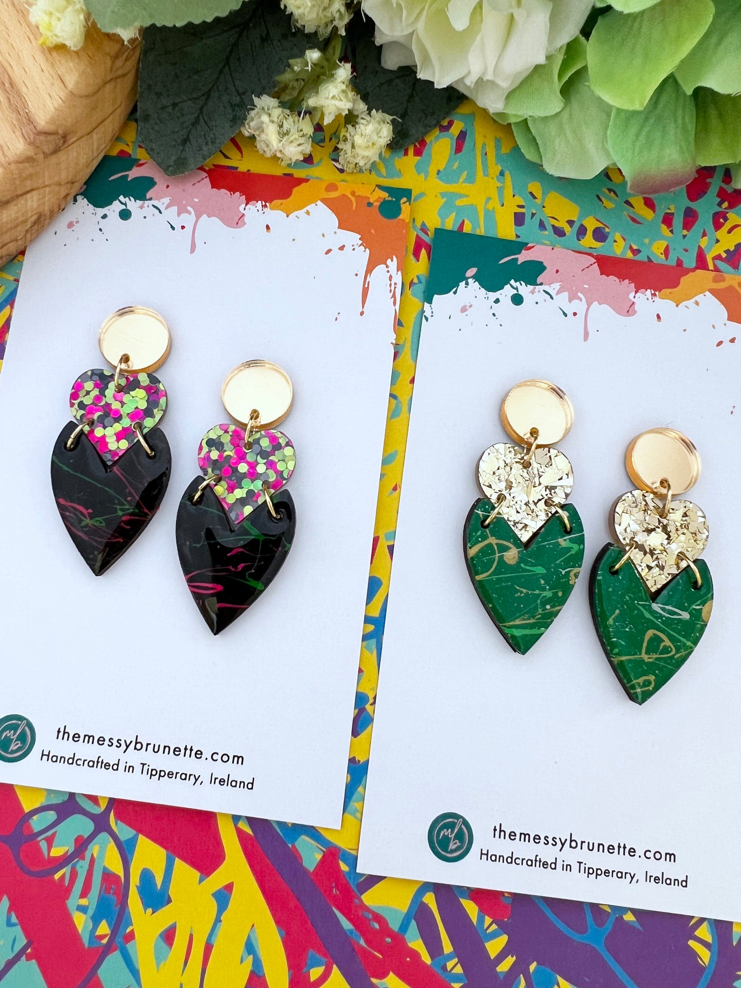 Pair of colourful earrings on a colourful card with 'the messy brunette' branding.