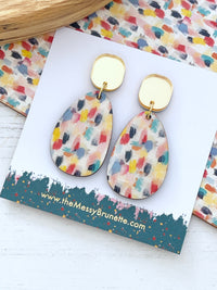 paint effect wooden earring on a card with the messy brunette branding