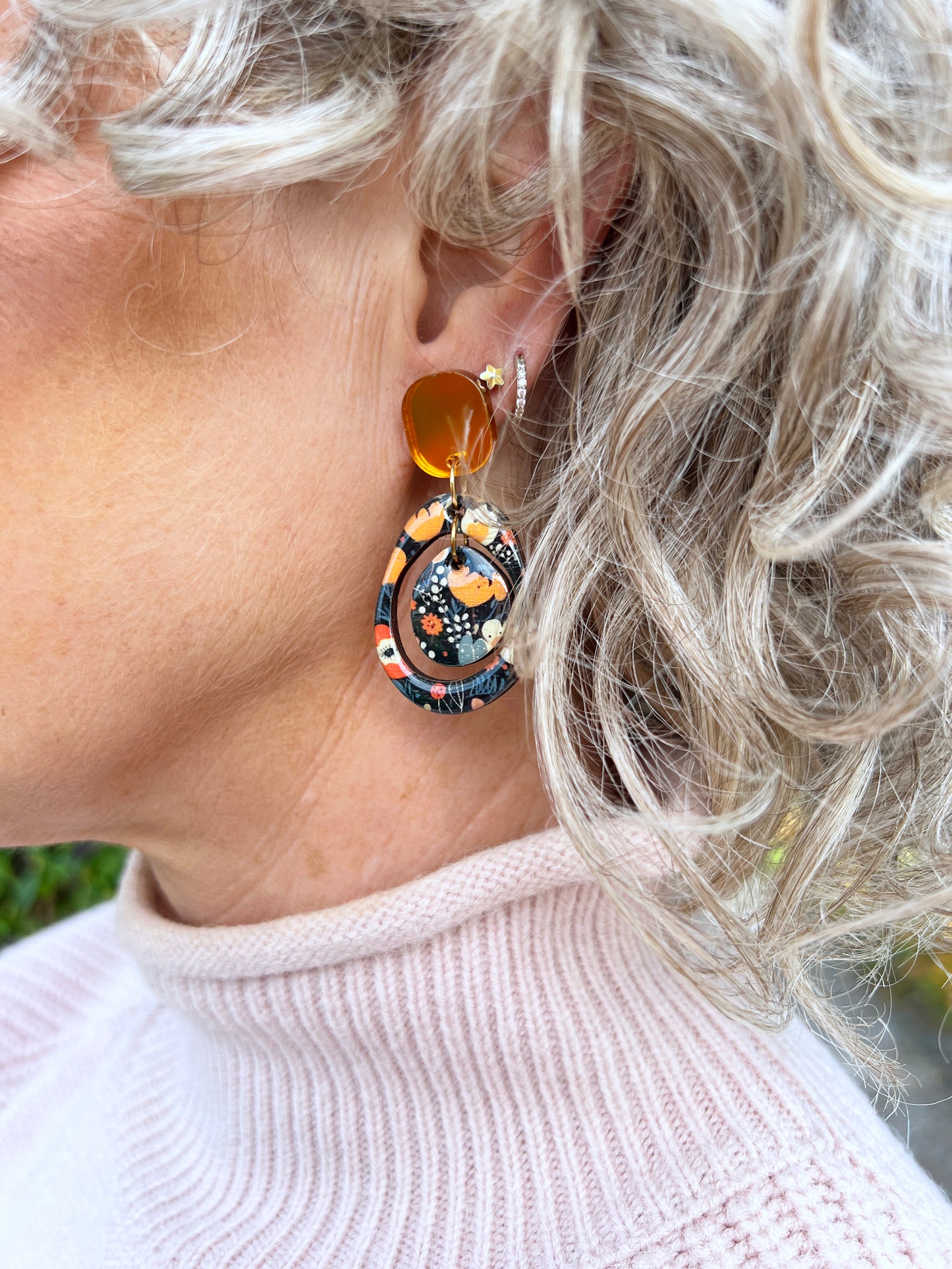 Close-up of a person wearing a colourful autumn inspired earring from the messy brunette jewellery brand