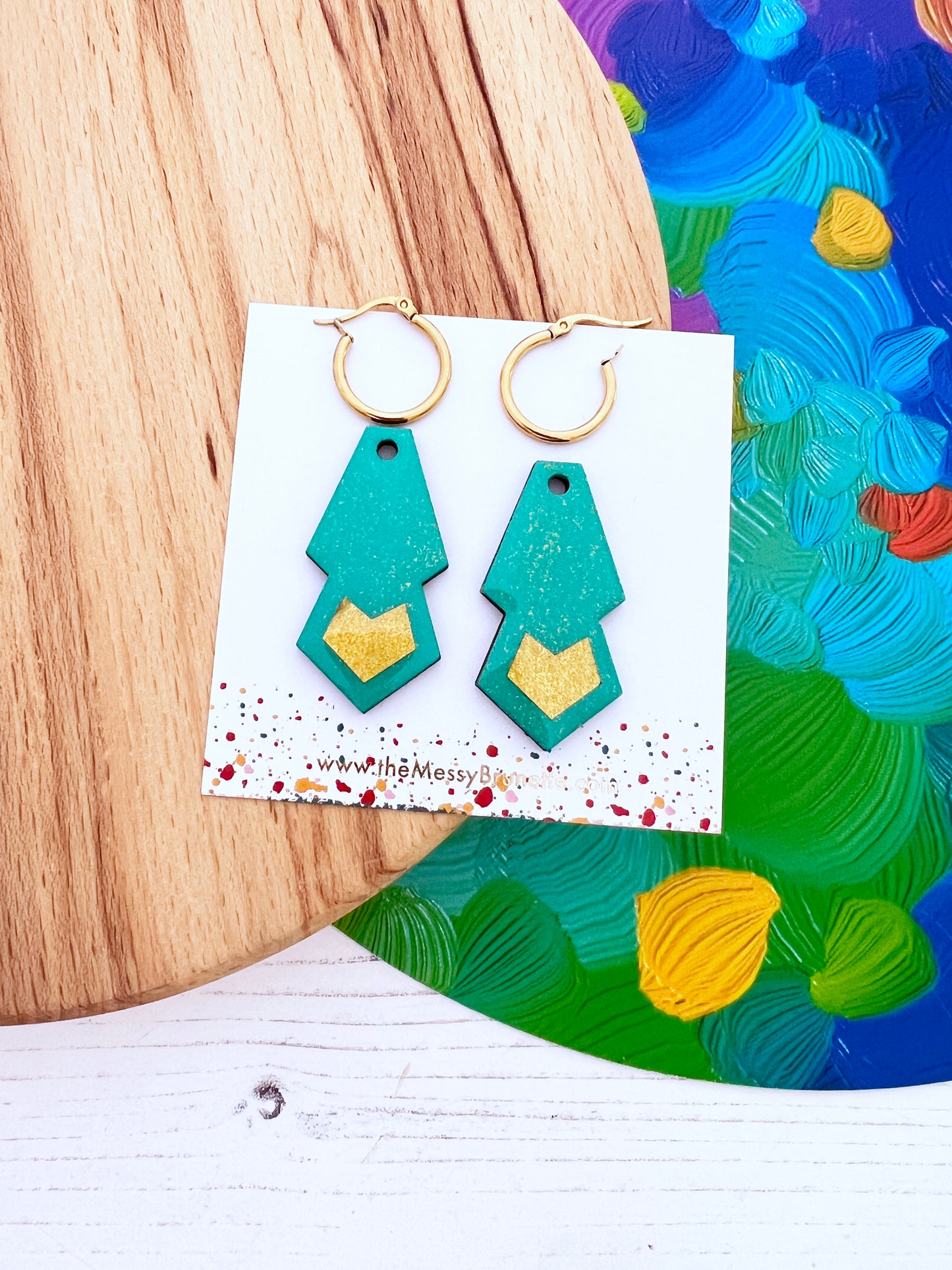 Mint green and gold hoops earrings on a white card