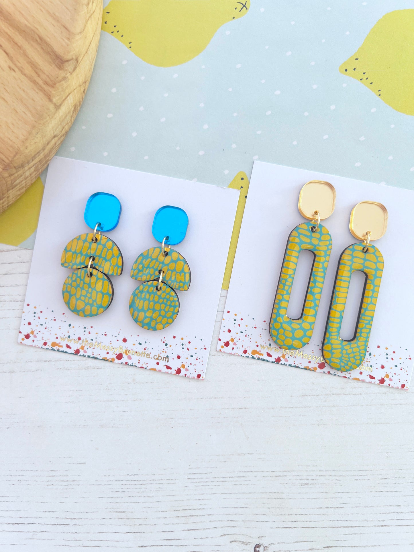 Pair of blue and yellow earrings on a white card with a yellow and blue background
