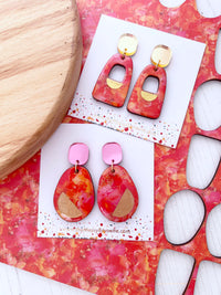 Colorful orange and pink ink abstract earrings on a white background. Irish Made jewellery by The Messy Brunette