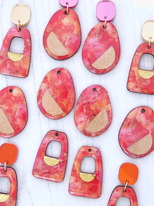 Colorful orange and pink ink abstract earrings on a white background. Irish Made jewellery by The Messy Brunette