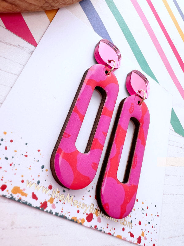Colorful abstract earrings on a patterned card