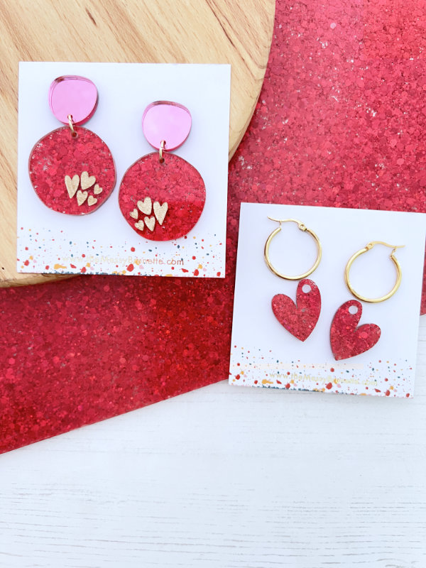 Pink Confetti Sparkle Heart Earrings, one pair round shape and second shape is lopsided hearts