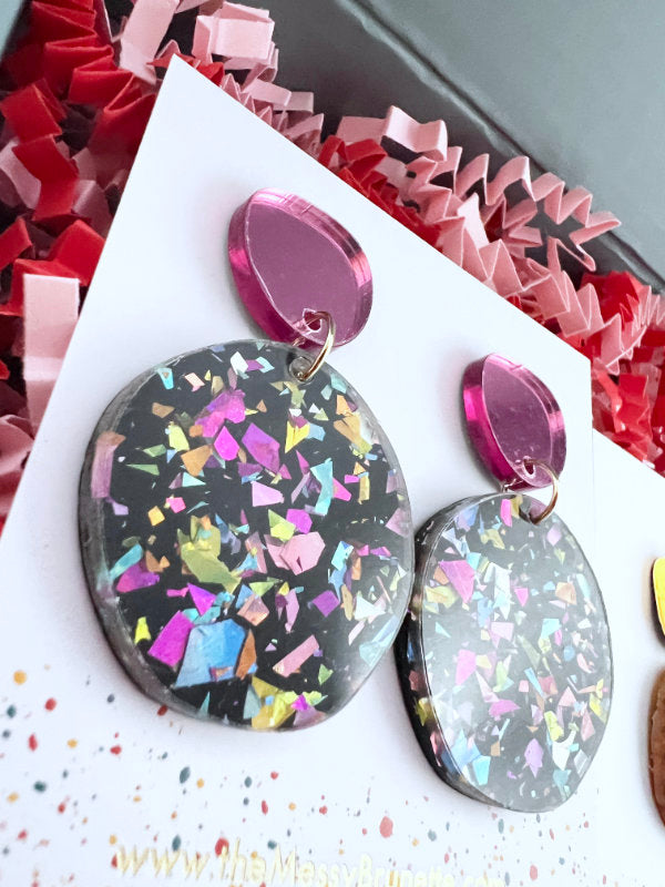 Multicolored confetti earrings on a white card with a colorful background