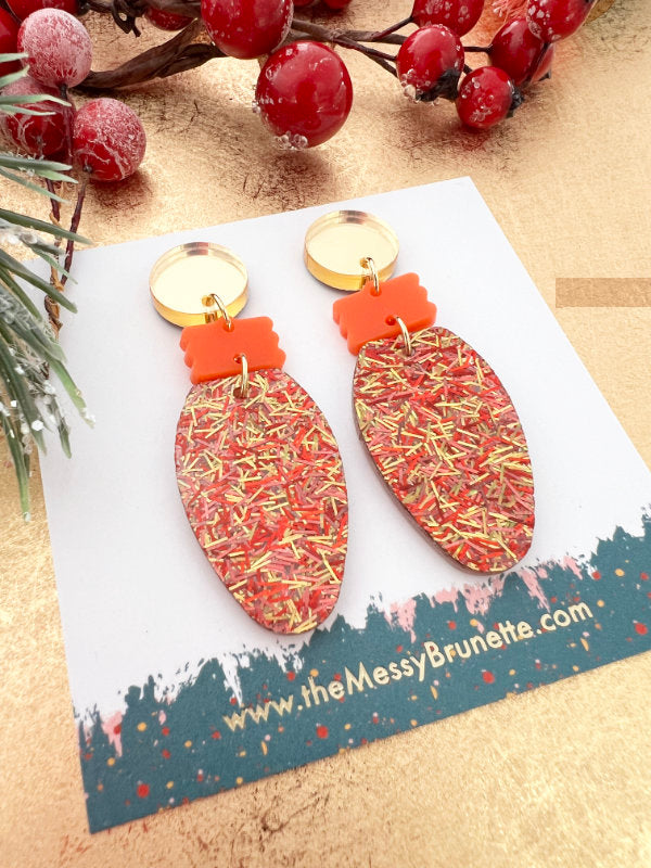 Christmas Light Bulb Earrings on a branded card with berries and greenery in the background