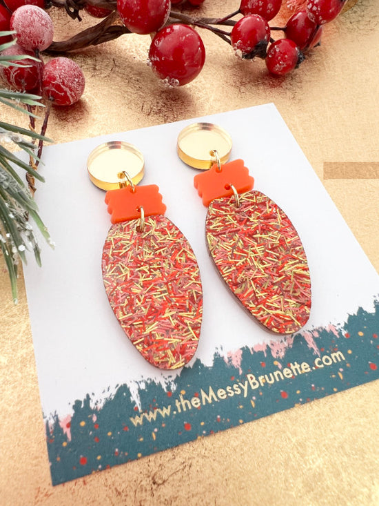 Christmas Light Bulb Earrings on a branded card with berries and greenery in the background