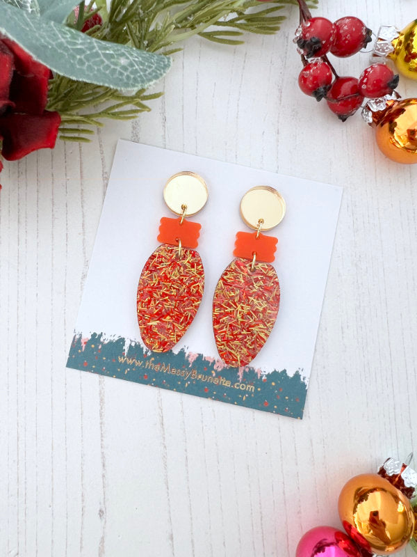 Christmas Light Bulb Earrings on a branded card with berries and greenery in the background
