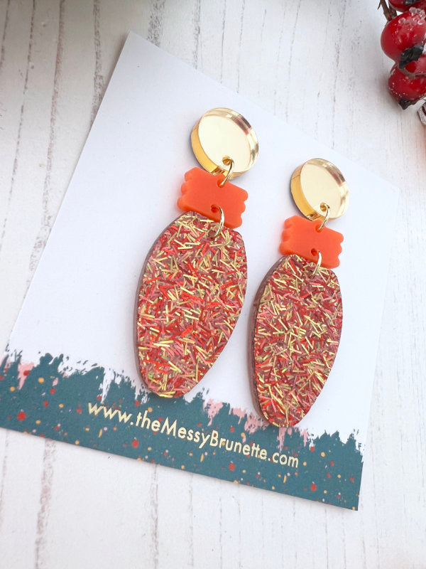 Christmas Light Bulb Earrings on a branded card with berries and greenery in the background