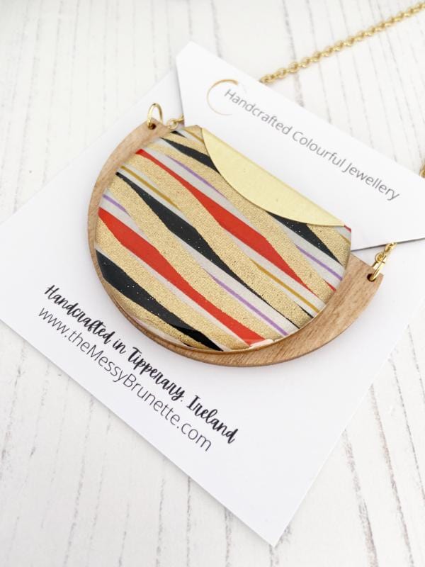 Gold Swirls Handmade Necklace made from FSC wood with gold swirls against black, white red stripes