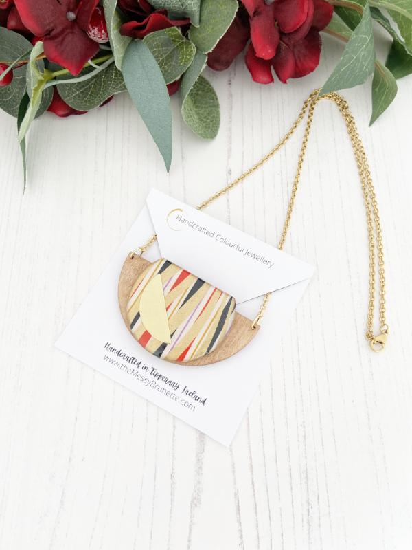 Gold Swirls Handmade Necklace made from FSC wood with gold swirls against black, white red stripes