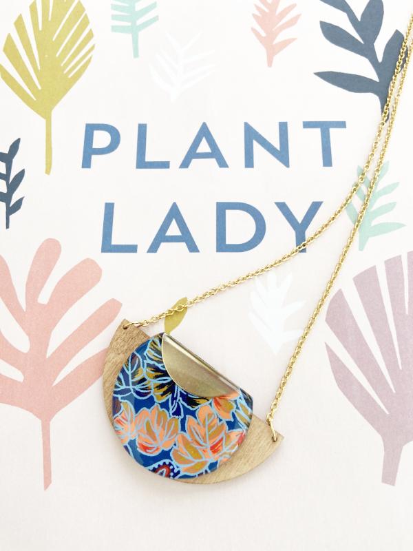 Load image into Gallery viewer, Tropical Leaf Handmade Wooden Necklace, made with FSC birch and hand screened paper with a leaf design in shades of blue, red and peach, finished with gold necklace
